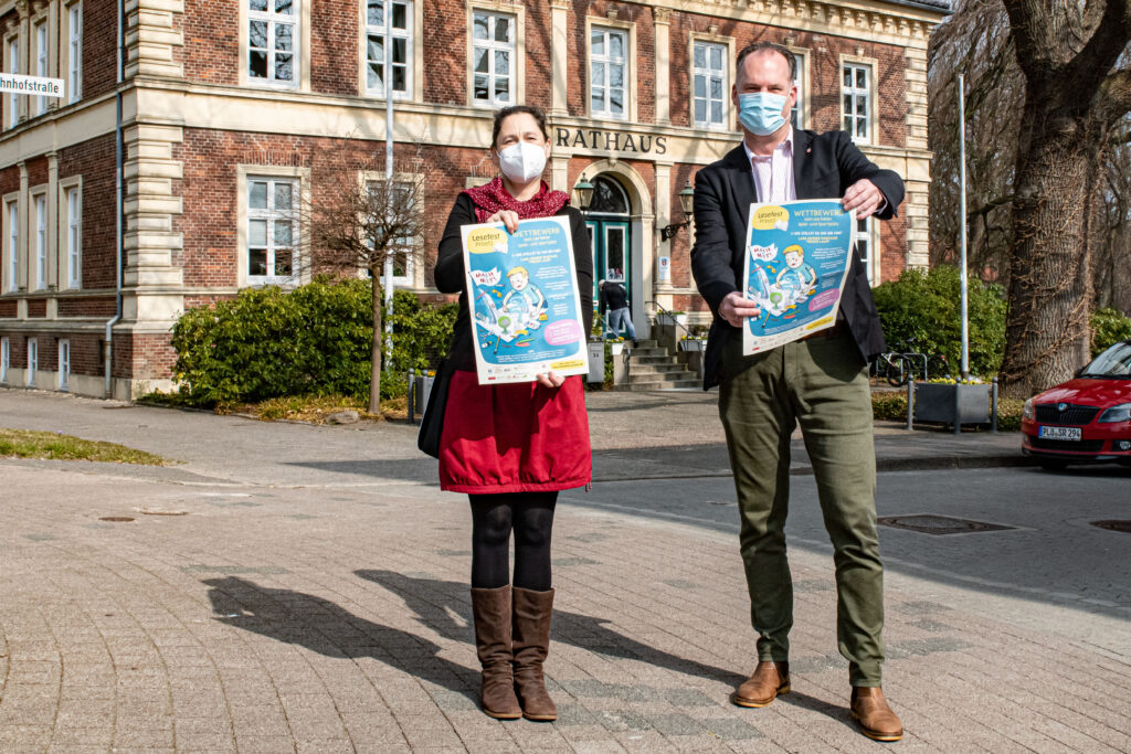 Illustratorin Franziska Ludwig und Bürgermeister Björn Demmin präsentieren das Plakat des Lesefest-Wettbewerbs